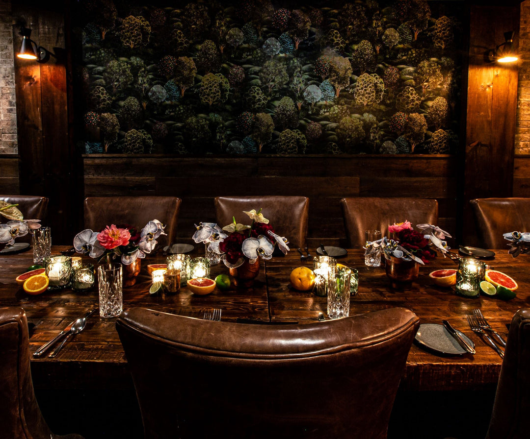 dark moody tablescape with tree wallpaper behind it 