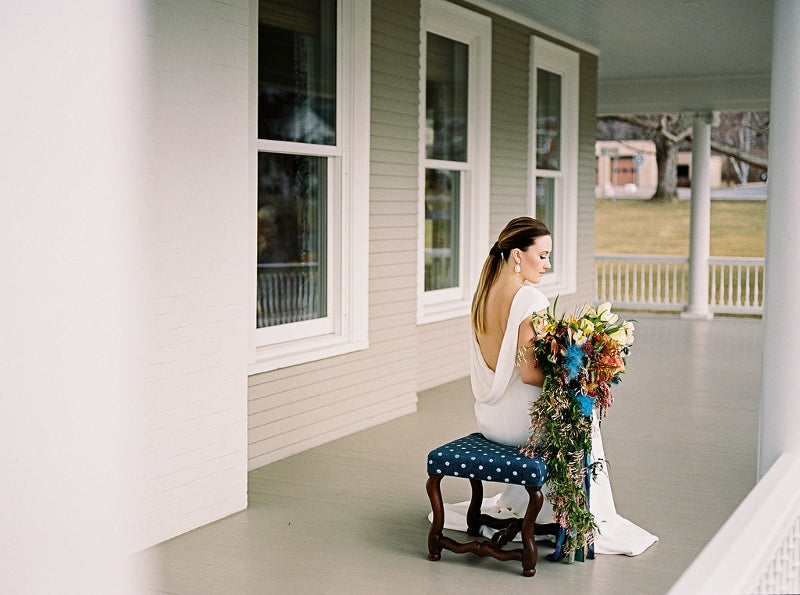 woman in bridal gown sitting holding bridal bouquet