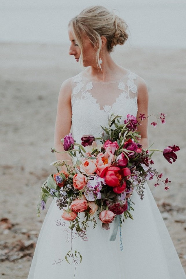 Jewel tone bouquet with coral peonies at the arbor at the port