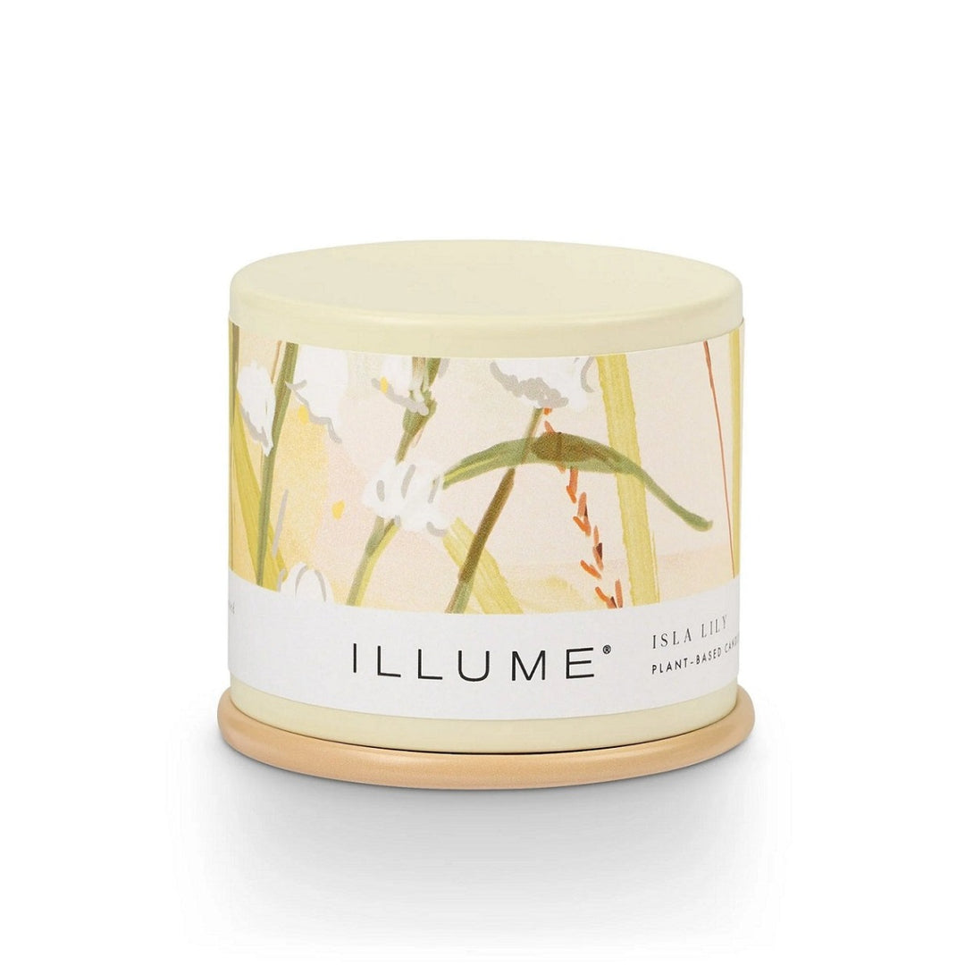 Demi Vanity Candle | Illume | A small tin candle will a soft yellow color and a lily floral label.