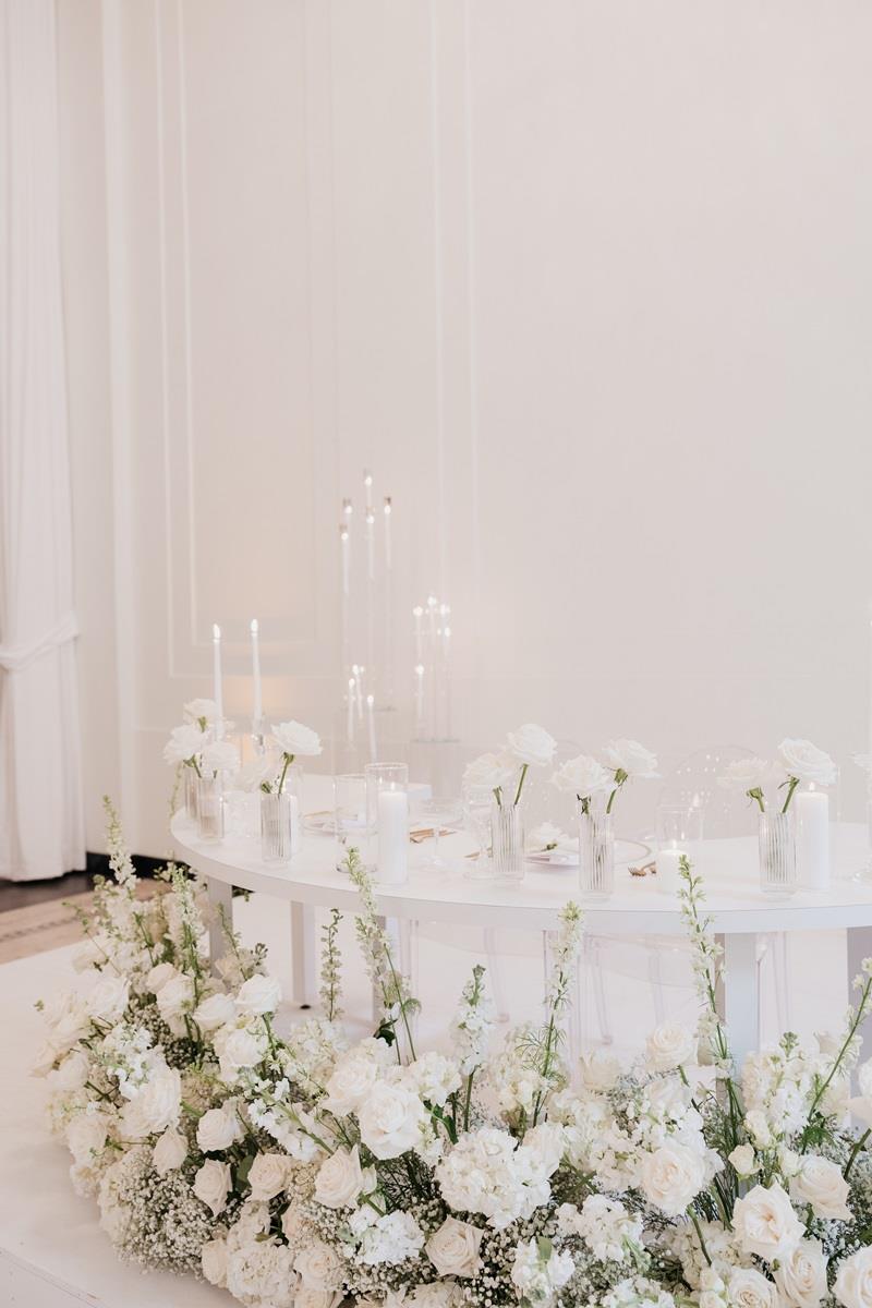 Half moon sweetheart table white blooms surrounding it in a half circle