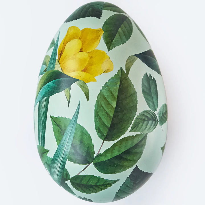 Gava Gifting | A Reusable Swedish Tin Egg "Blad" A green egg with a primarily green plant design with a yellow flower.