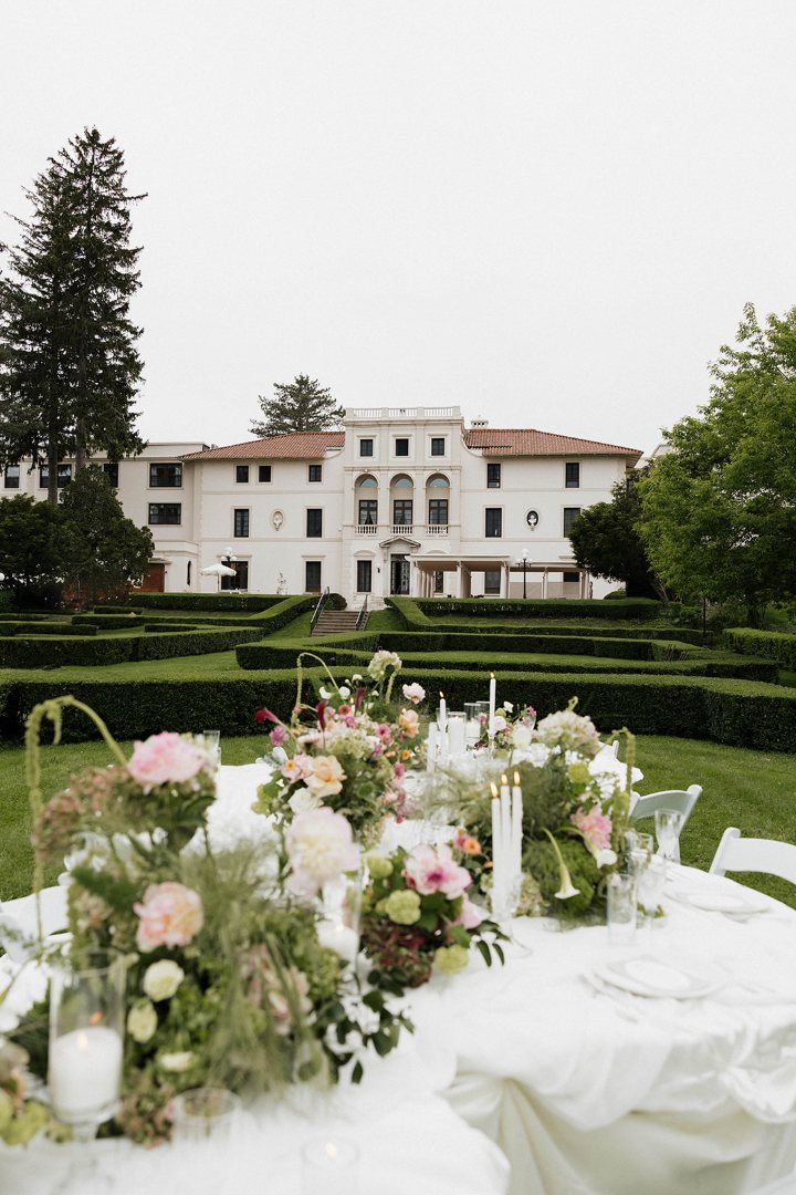 Geneva On The Lake | Styled Shoot. Fresh flower arrangement with roses, calla lilies, hydrangea, orchids, ameranthus, and more. Flower arrangements in the foreground with geneva in the background.