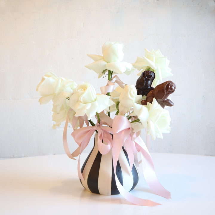 Black and white striped vase with chocolate roses and ribbons