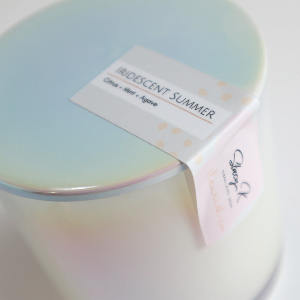 Iridescent Summer | A close up on the iridescent lid and label that reads "Iridescent Summer. Citrus + Mint + Agave".