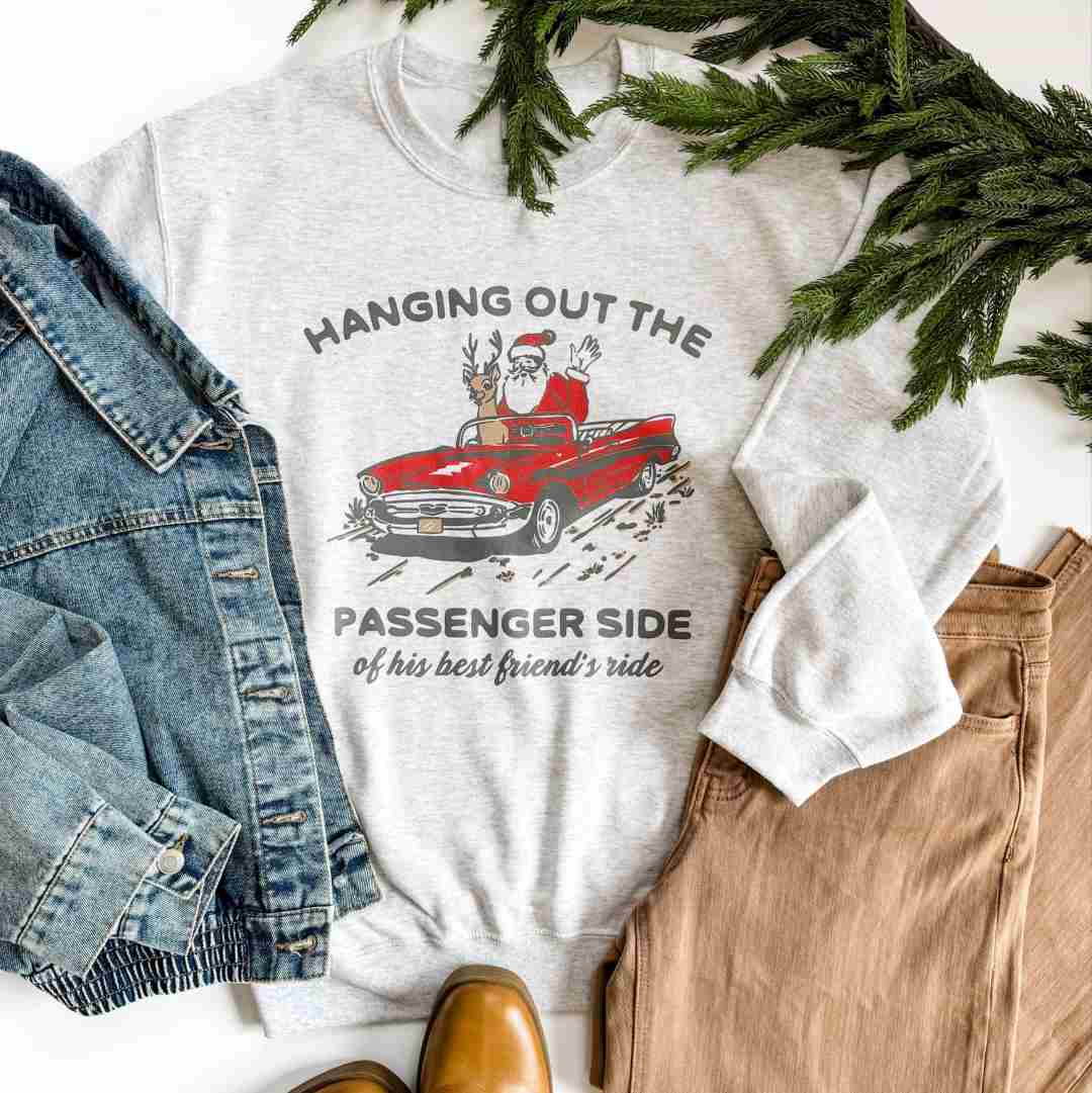 Mugsby | Santa and Rudolph in a car graphic on an ash gray crewneck sweatshirt. Text "Hangingout the passenger side of his best friend's ride.