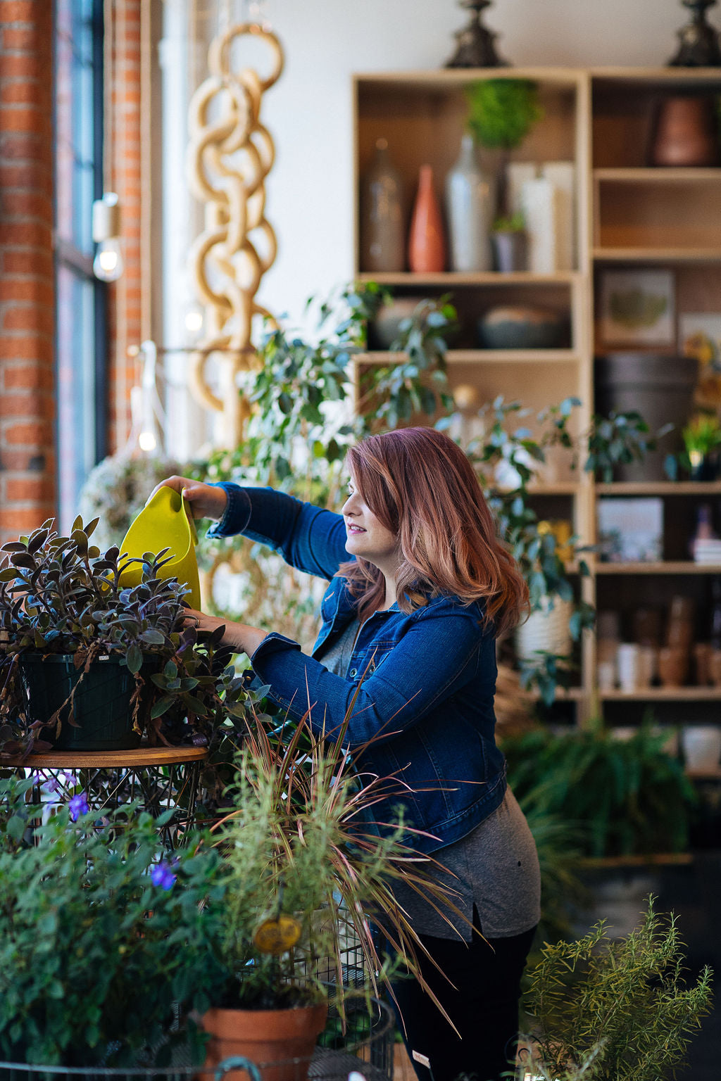 Stacy K Watering plants in the studio