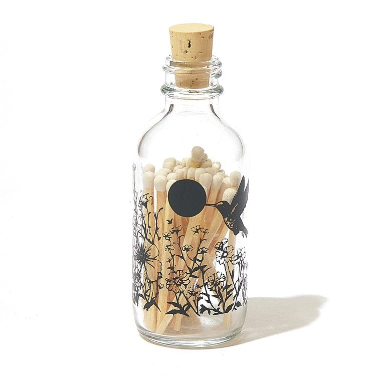 Skeem | Matches in a small glass bottle with humming birds and a cork top.