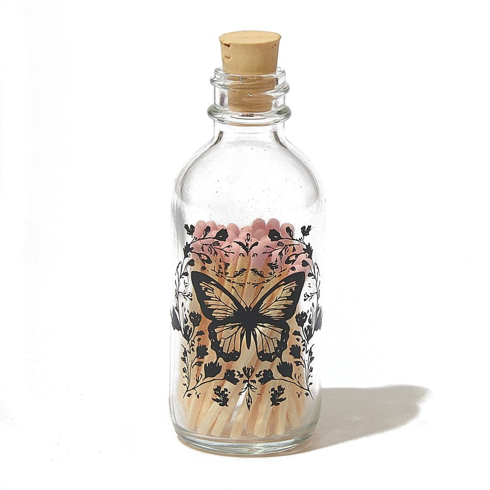 Skeem | Papillon Mini Match Bottle | A glass bottle with a butterfly pattern and cork lid.