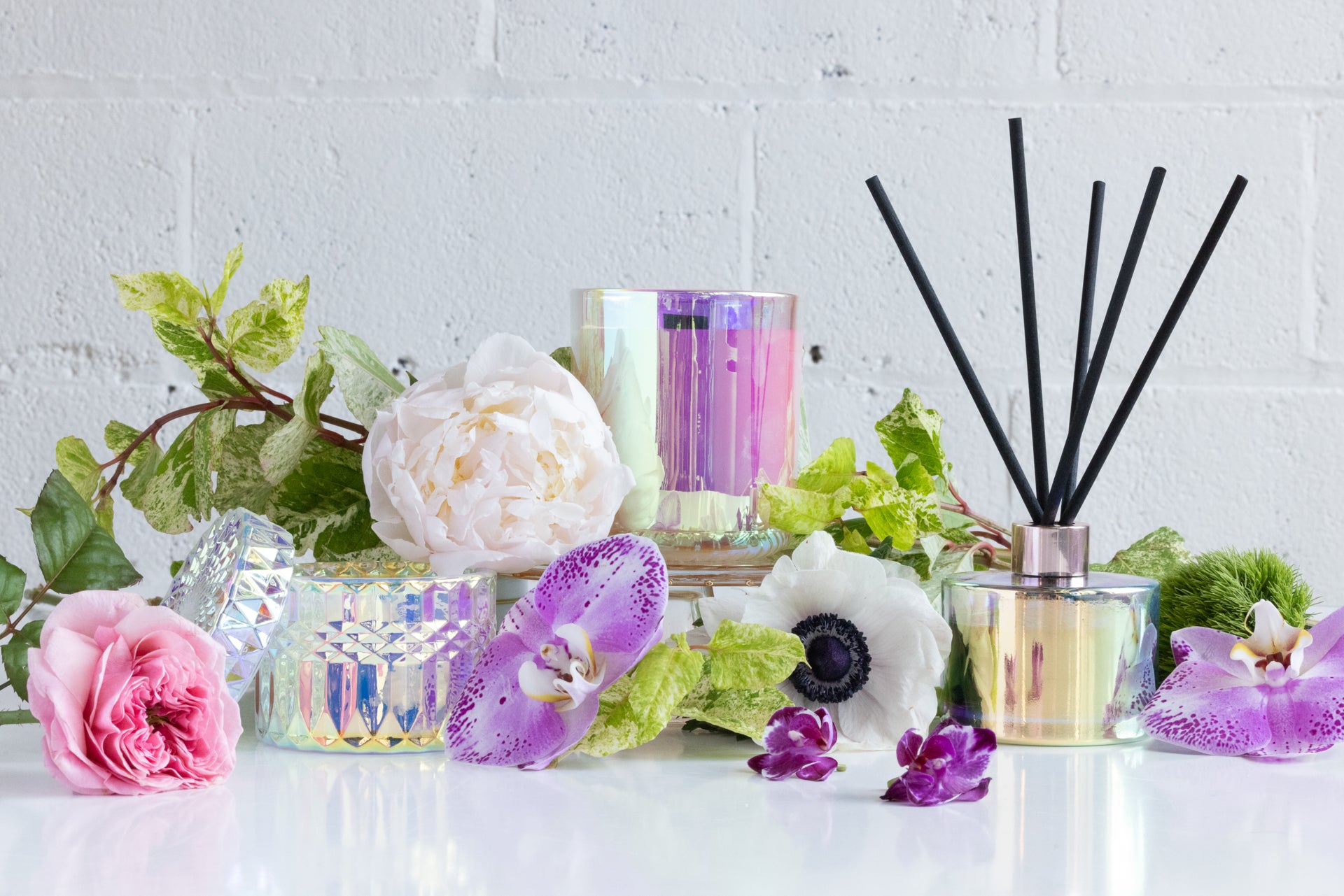 Launch of Stacy K Florals home fragrance line bloom in iridescent vessels with flowers around it