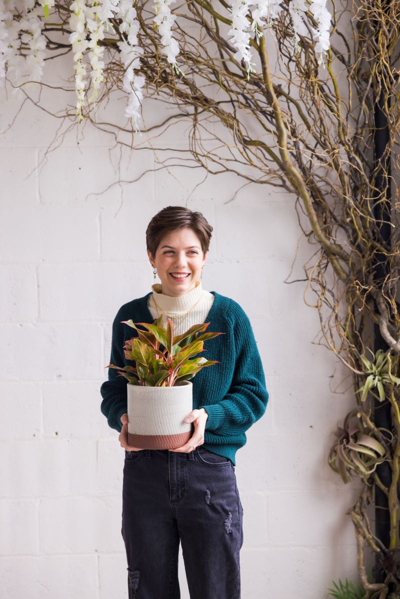 Head shot of sadie holding a plant