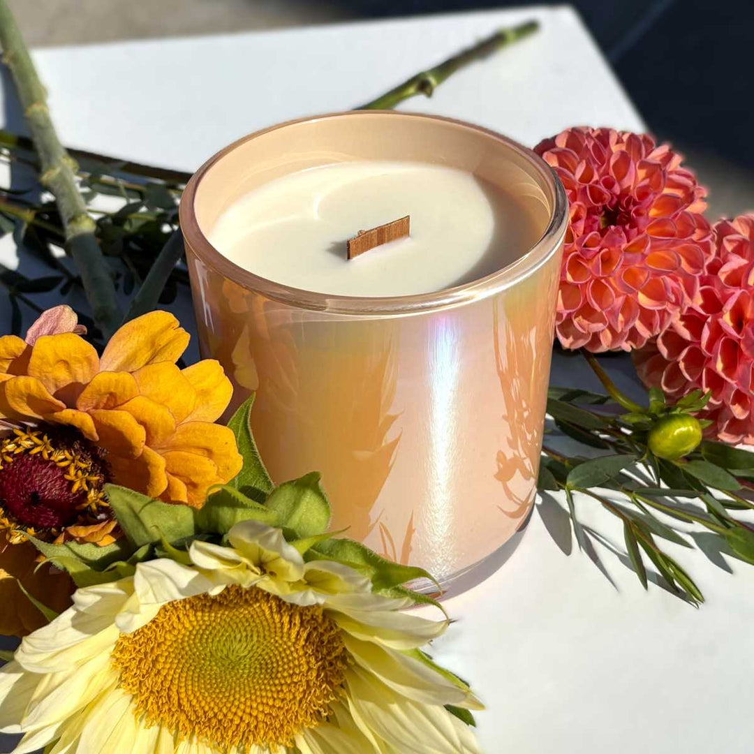 Stacy K Floral | Fleurish Co | Candle in a decorative holder surrounded by flowers on a white surface