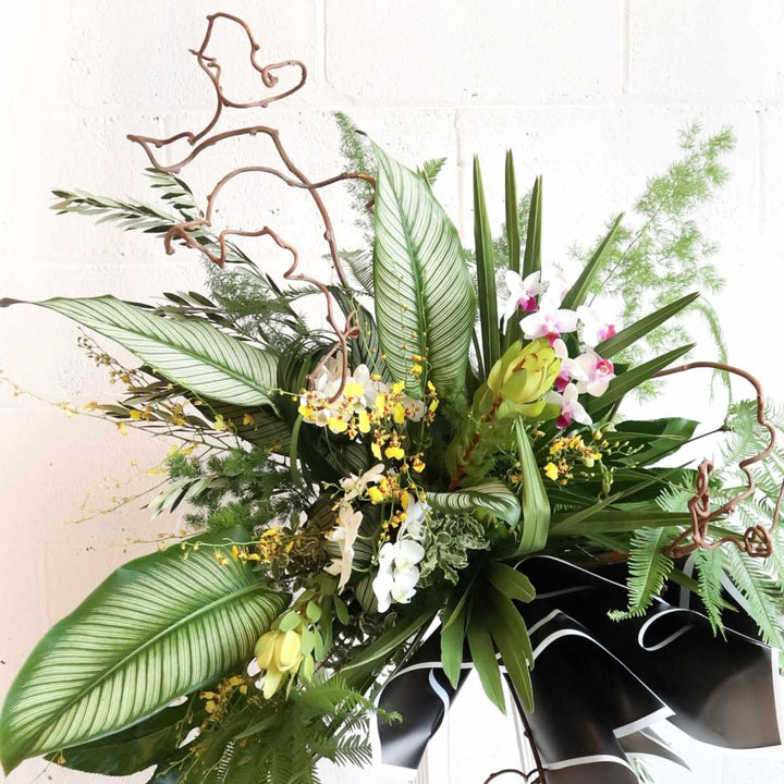 Stacy K Floral | natural standing spray, close up photo showing the orchids and curling branches.