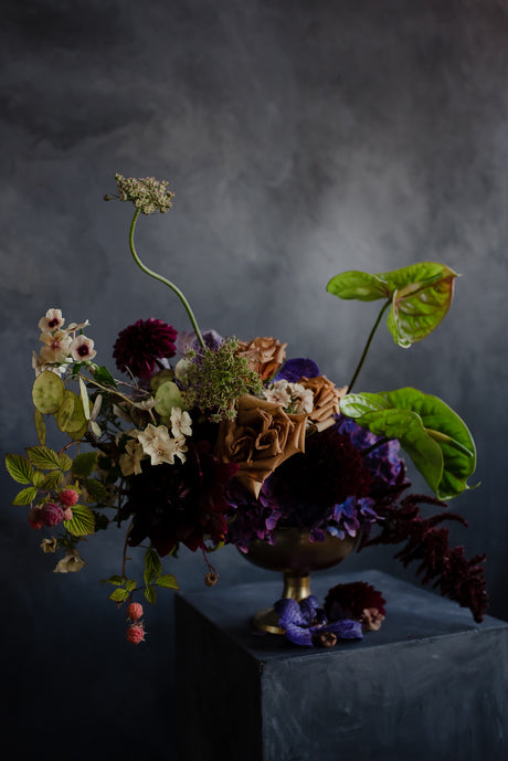 Dramatic centerpiece with dripping berries and rich jewel tone flowers