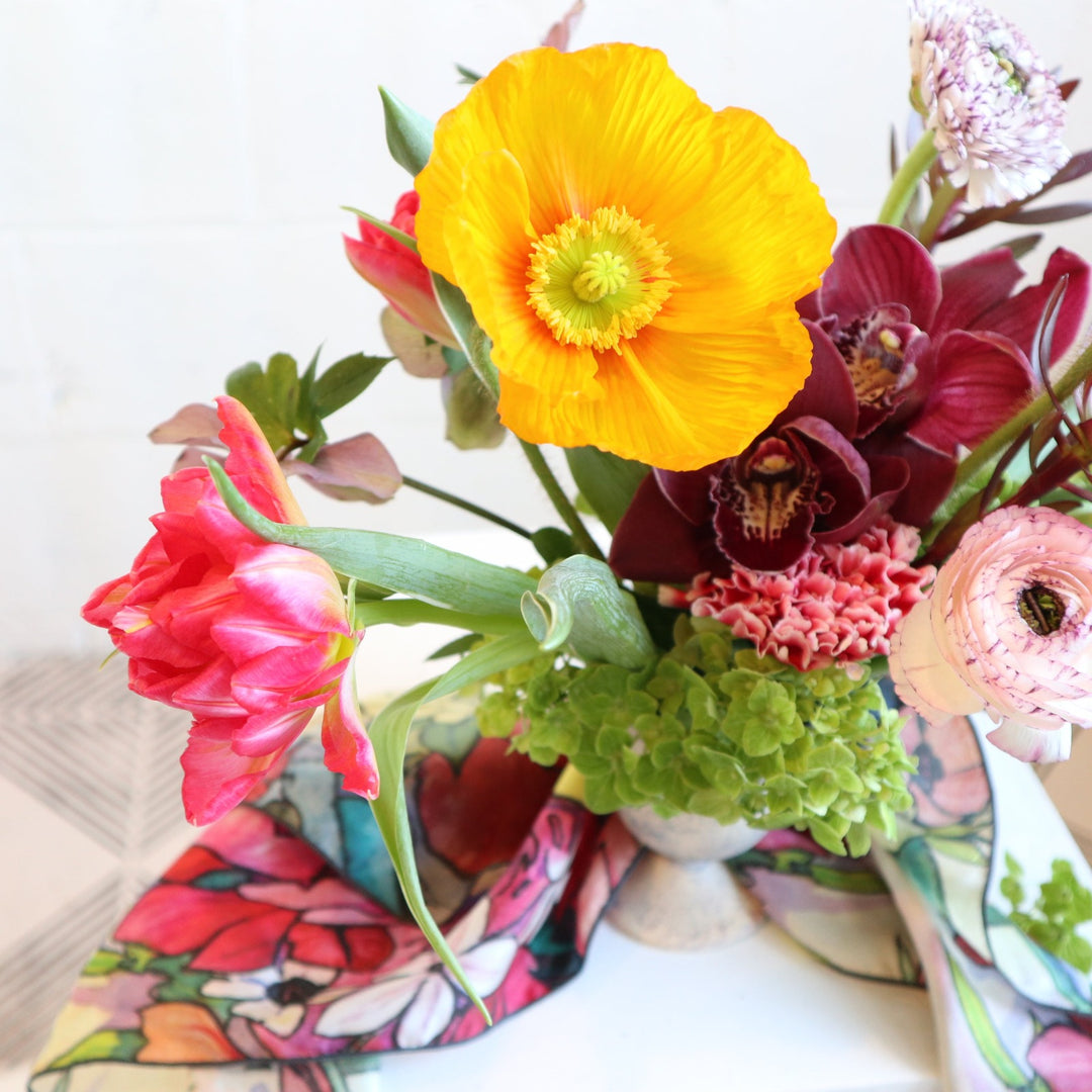 poppy, orchids, tulips. hydrangea, ranunculus pictured with a colorful silk scarf done by andrea durfee