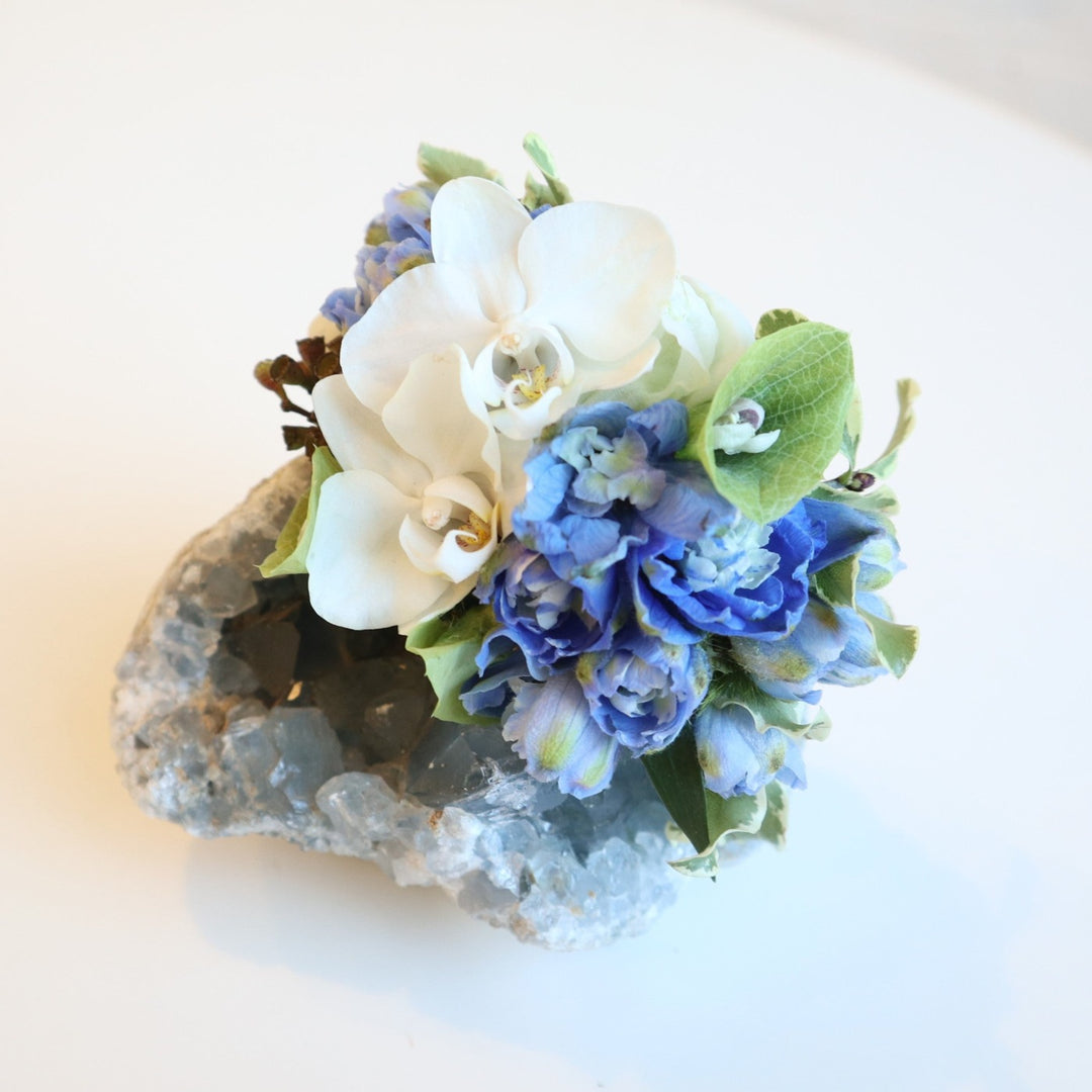 Corsage with two white mini orchids, blue delphinium, bits of bells of ireland.