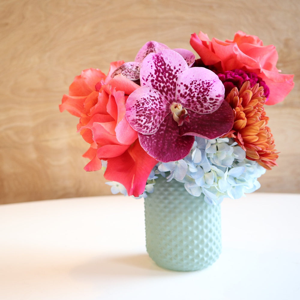Fairy | Vased Arrangement | Close up highlighting the purple orchid and the pink/orange rose.