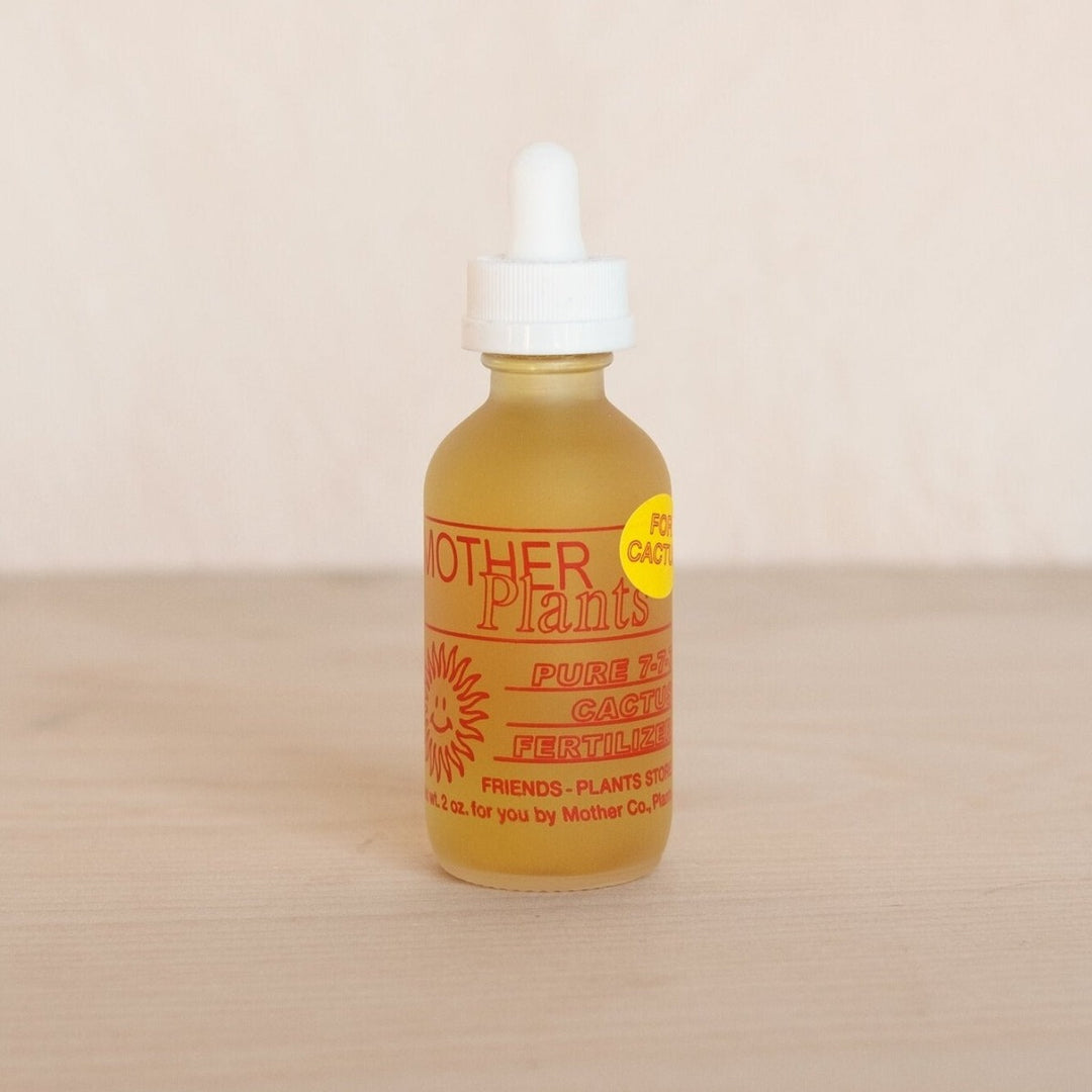 Cactus Fertilizer | A small glass bottle with a dropper. The label writing is red and reads "Mother Plants, Pure 7-7-7 cactus fertilizer. 2oz.