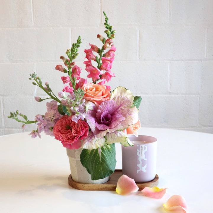 Fleurish and Floral Gift Set| This Gift set includes a Fleurish Co. candle with a custom designed Floral arrangement with a cream and gray checkered vase and tray to compliment. The Arrangement has two pink snapdragons, purple kale, one pink garden rose, two coral roses and three light purple stock