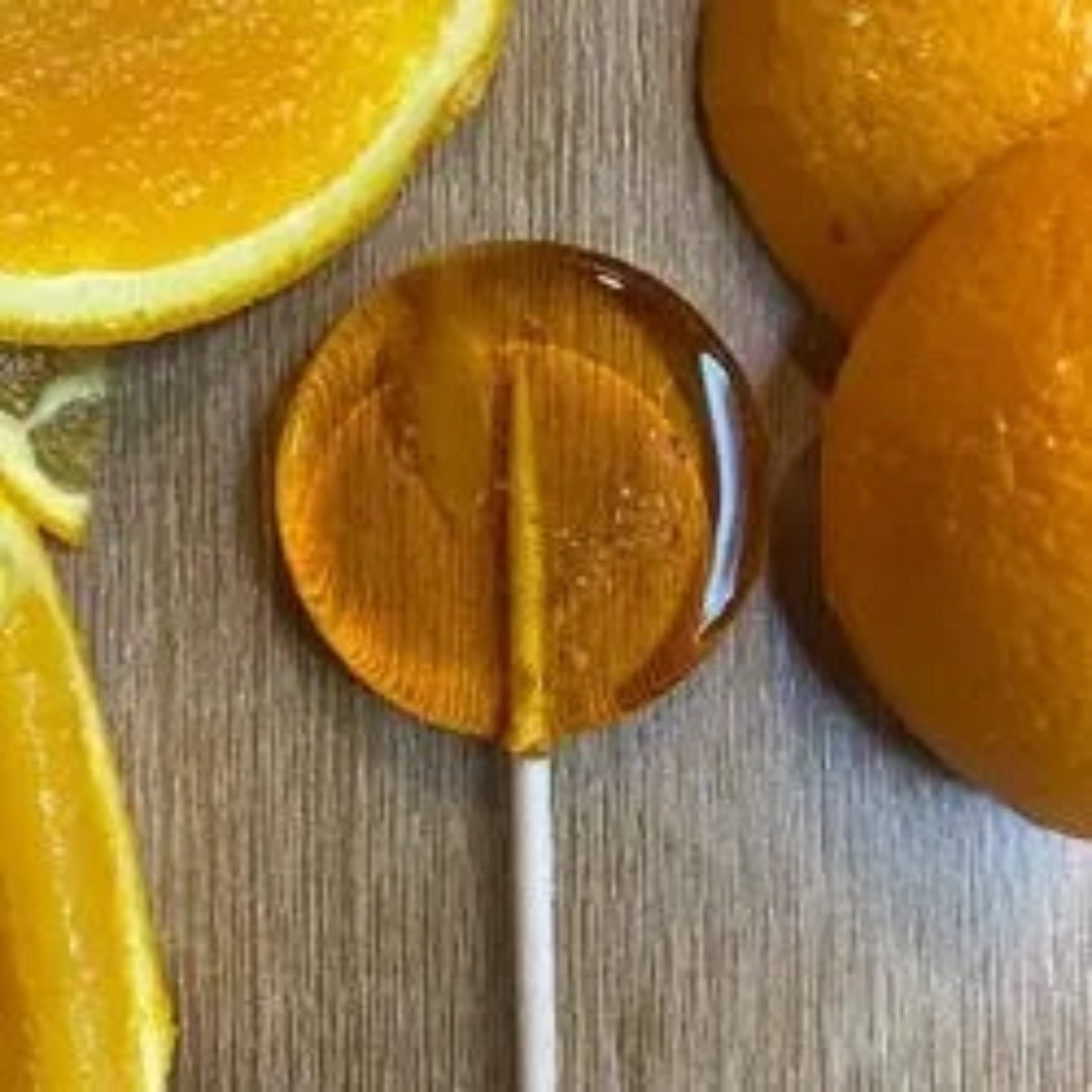 Good Lolli Orange Lollipop. Orange transparent lollipop photo taken against wooden background with decorative orange slices.