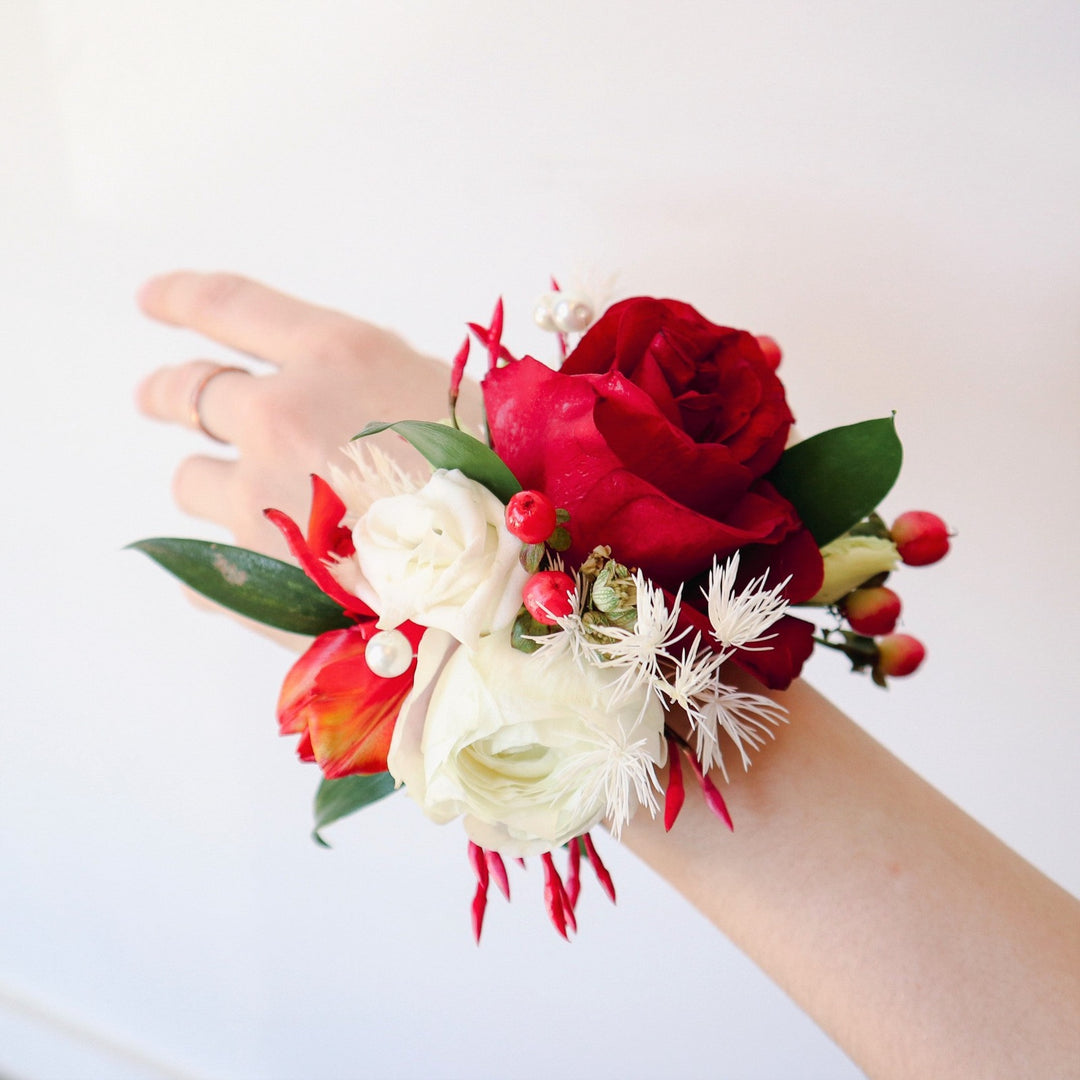 Red and White Corsage | A corsage with red and white roses, red berries, and other florals.