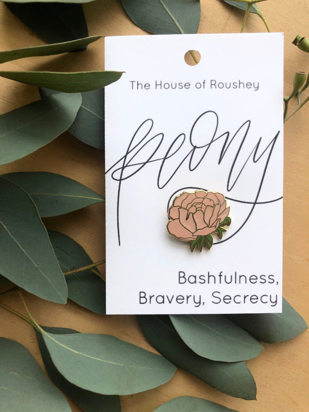 Enamel Pins by Christy Roushey | The House of Roushey, Pink Peony Pin. The bottom of the packaging reads "Bashfulness, Bravery, Secrecy".