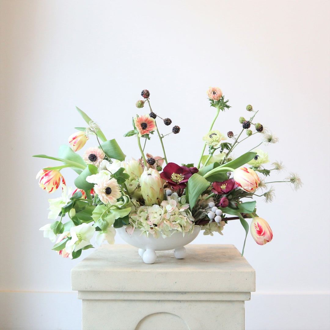 An arrangement with anemone, protea, helleborus, tulips, berries, brunia and hydrangea.