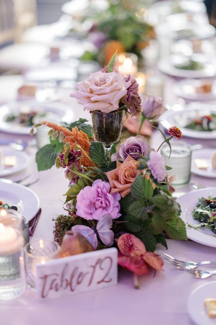 Close up on a centerpiece arrangement with pinks, greens, and oranges.