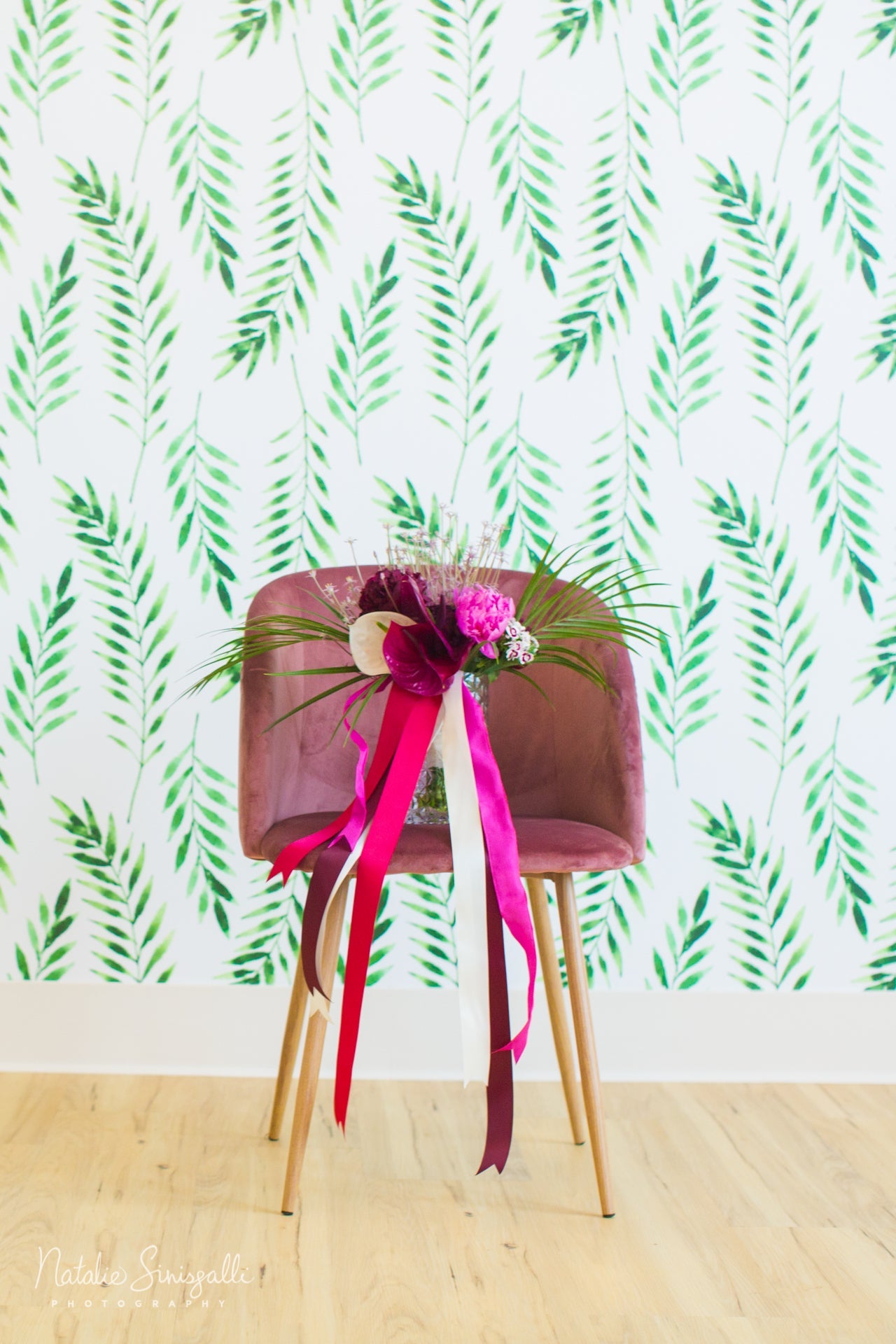 bridal bouquet in vase sitting on pink chair 