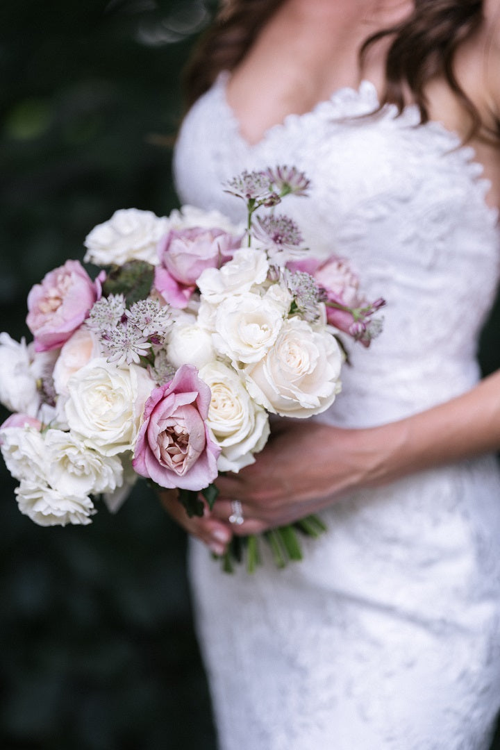 Cover image showing a detail image of the bridal bouquet. The bouquet has white and lavender florals with green accents.