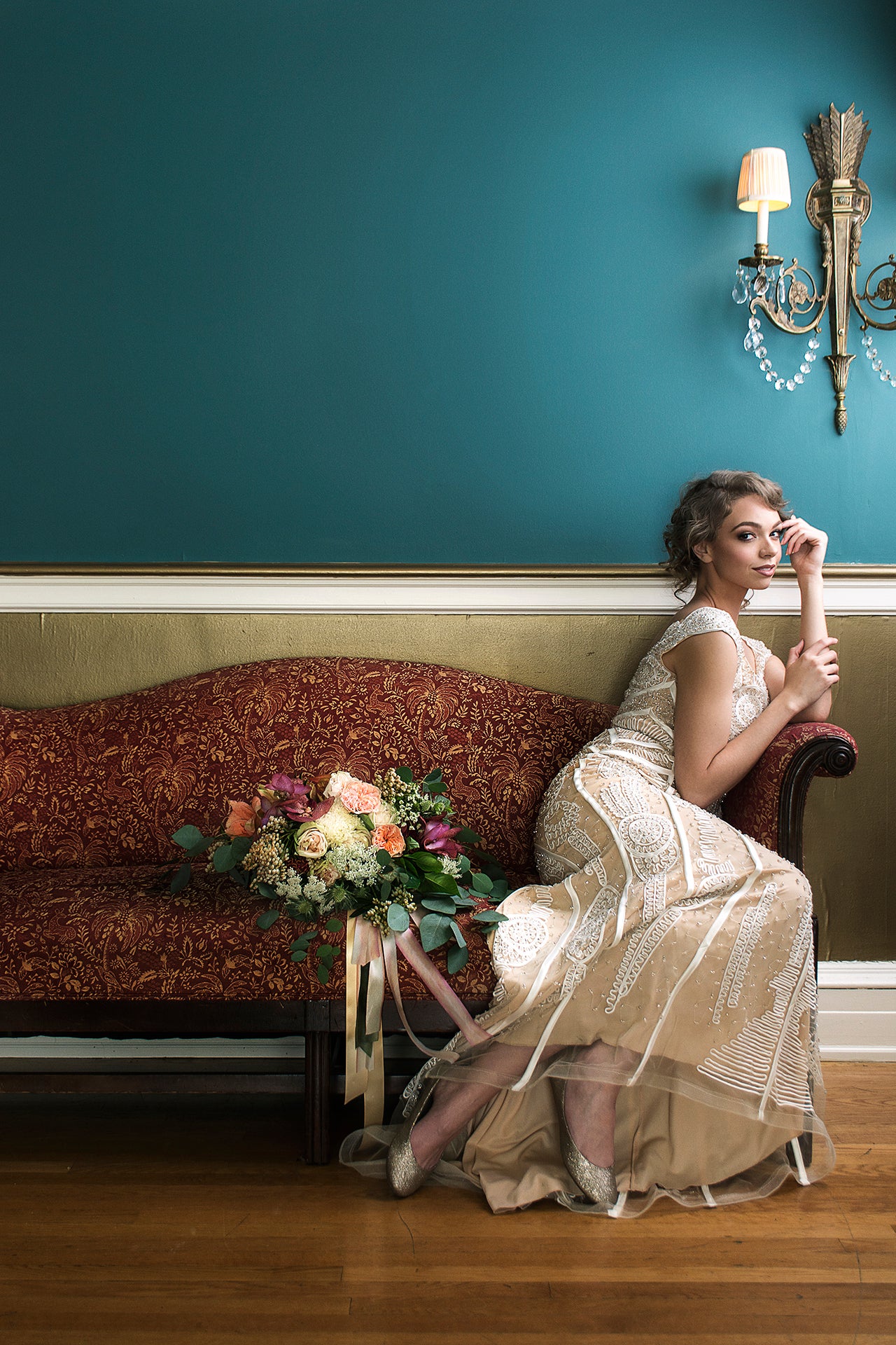 bride sitting on sofa with bouquet next to her 