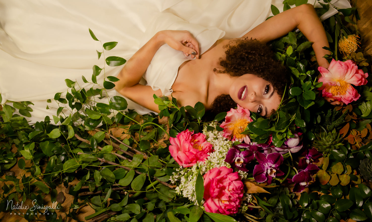 bride laying in flowers