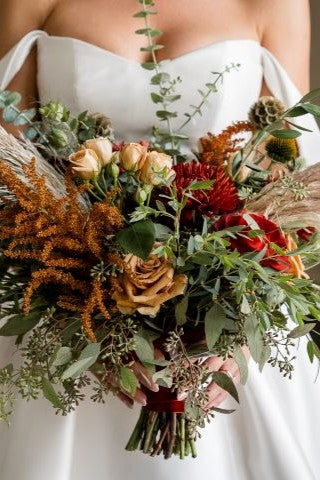 bride holding a fall colored bouquet