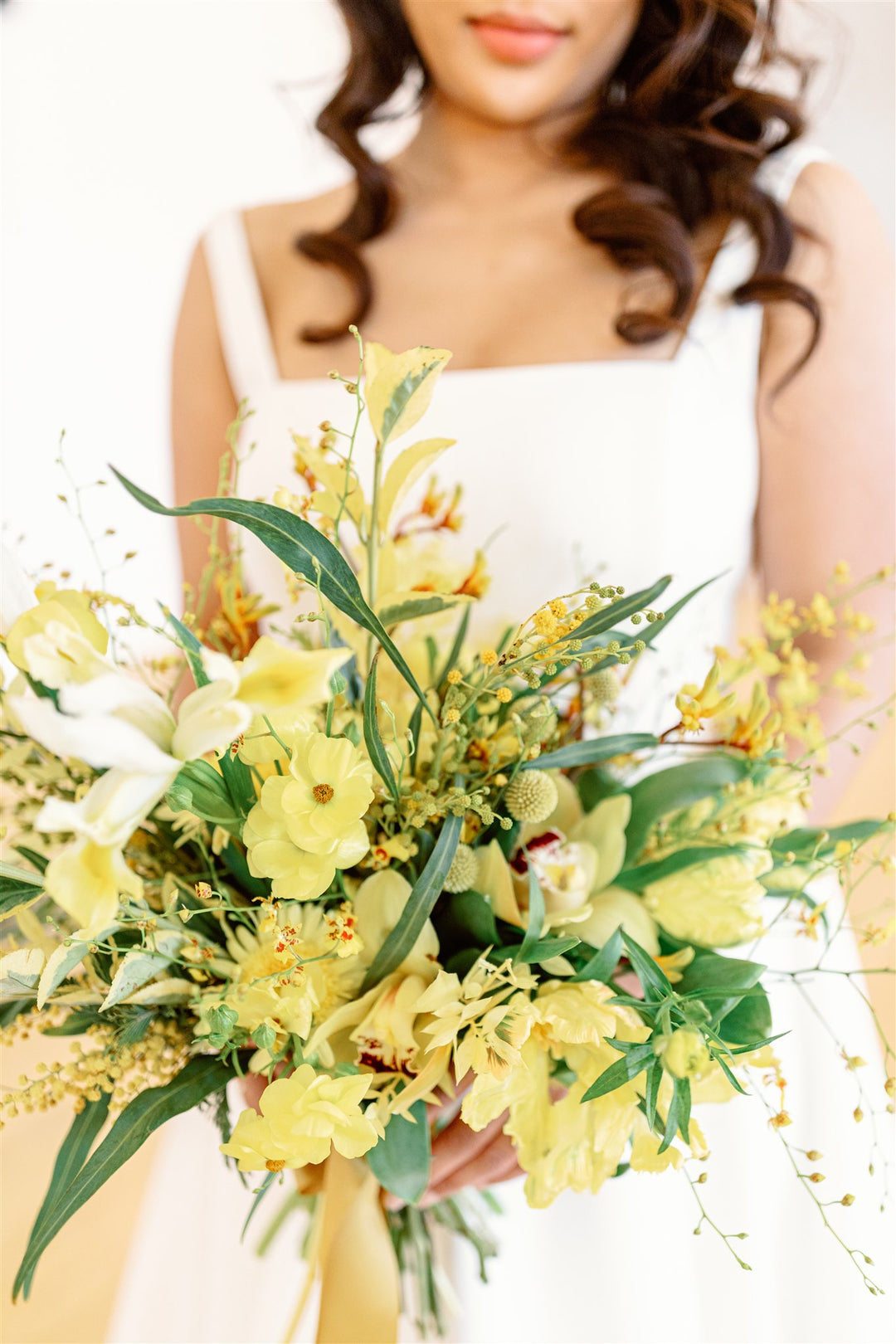 bride holding bouquet of yellow wildflowers