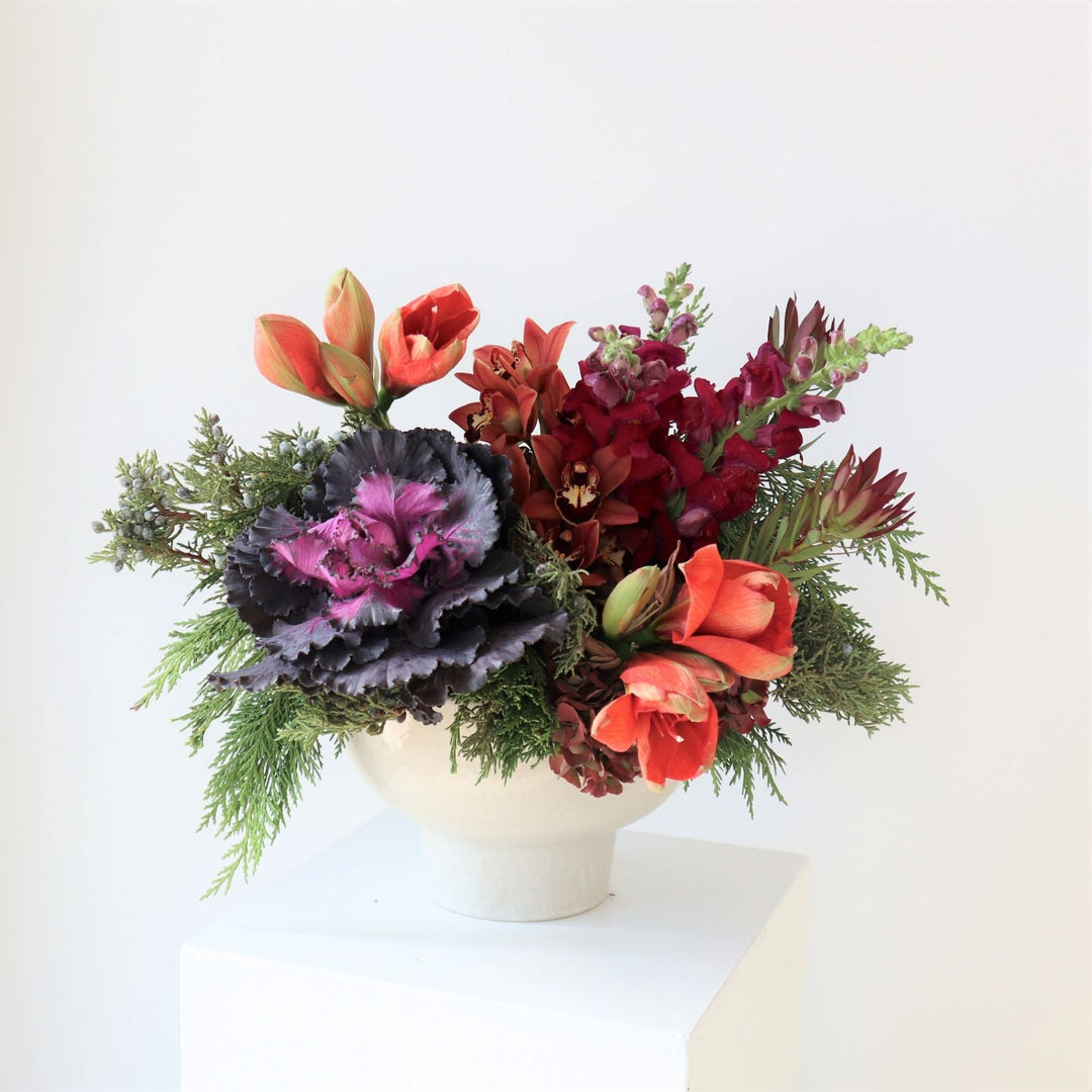 Jewel tone winter arrangement in a white bowl