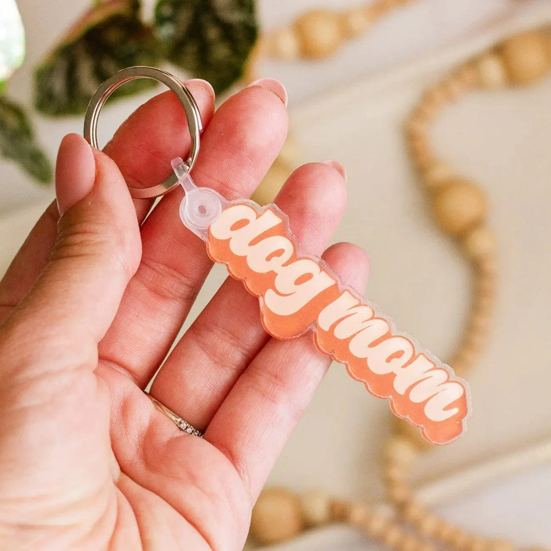 Keychains (Assorted Styles) | The Print Pantry | A keychain with text that reads "dog mom" in orange.