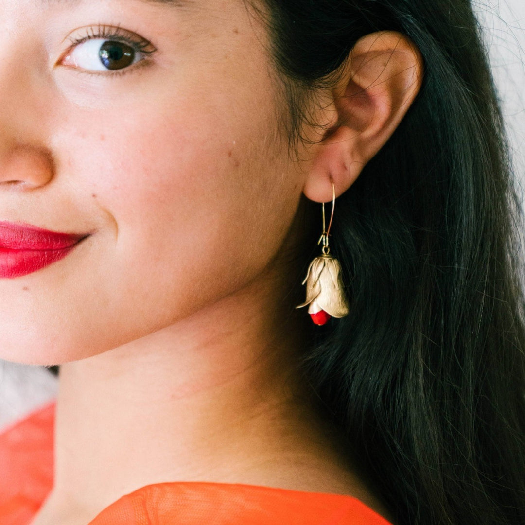 Nest Pretty Things | Red Flower Bud Hanging Earrings | A layered flower earring with a red beaded center. On a model for scale.