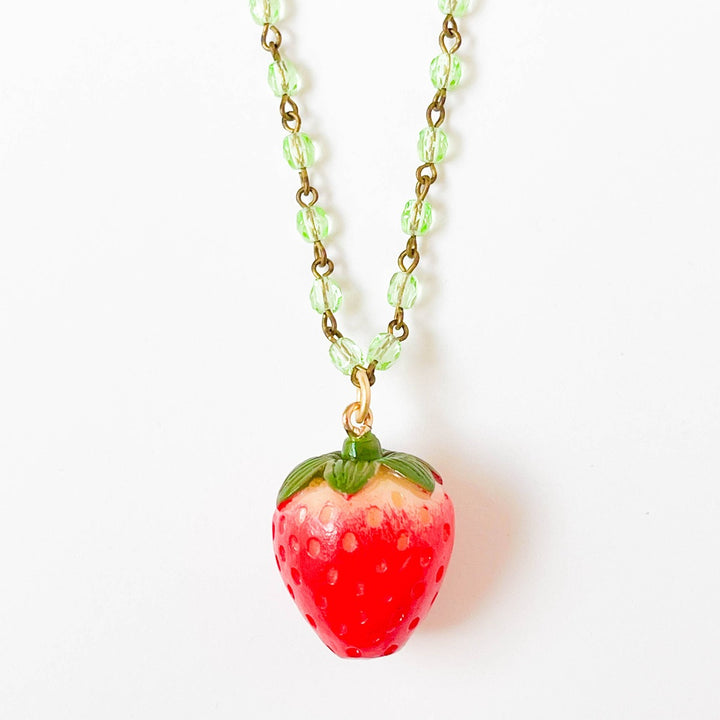 Nest Pretty Things | Kids Strawberry Charm Necklace | Closeup on the strawberry charm.