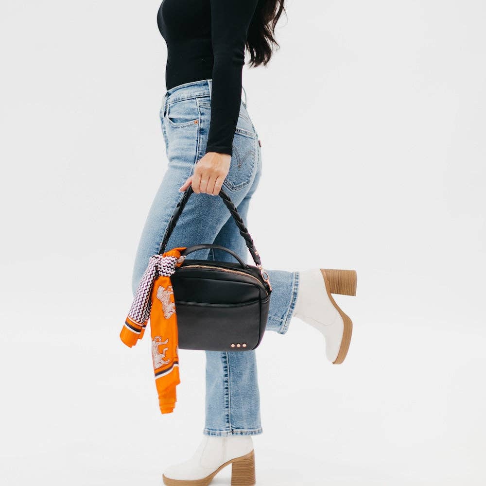 Model with an orange hair scarf styled on her handbag.