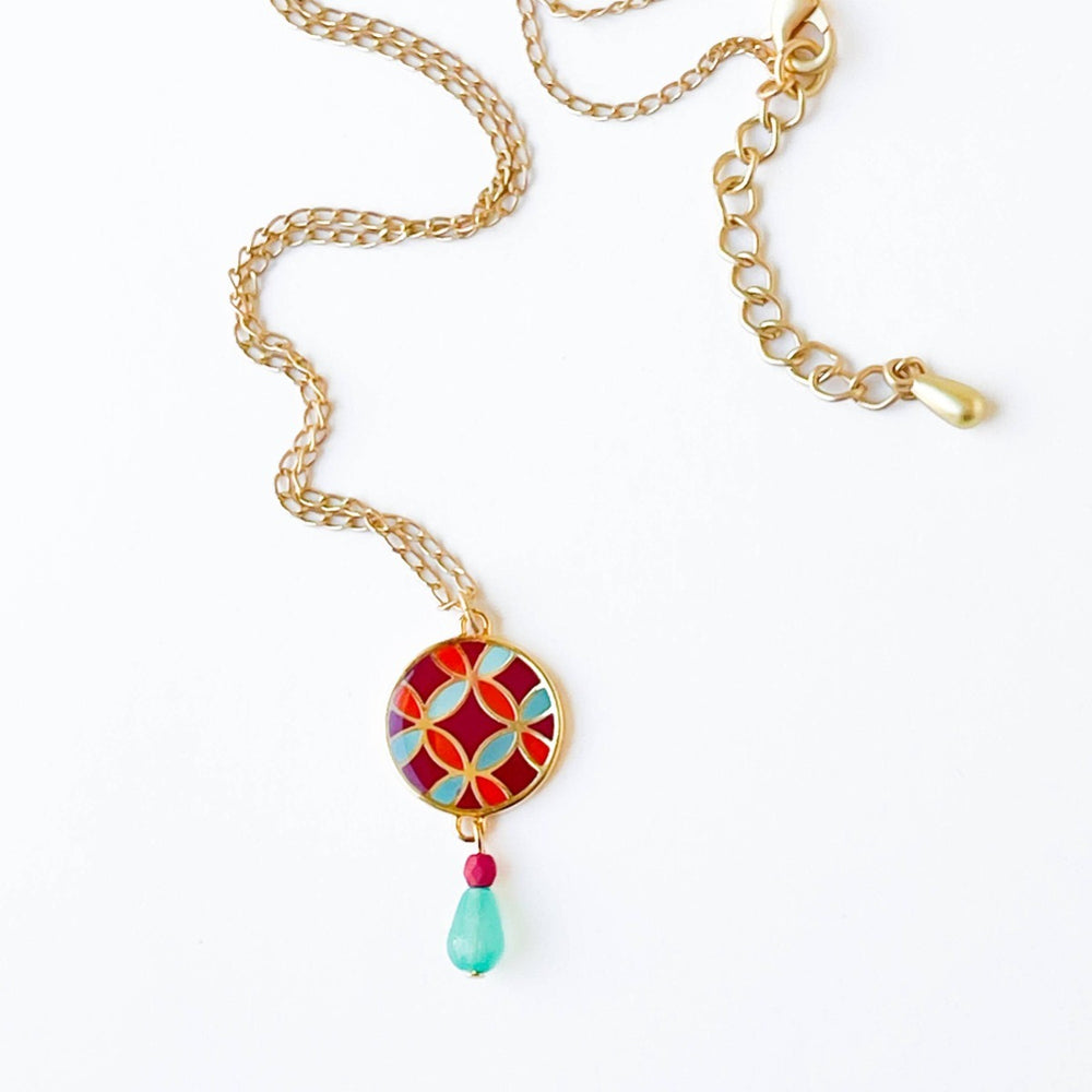 Nest Pretty Things | Mid-Century Pendant Necklace Assorted | Close up on the red/orange/blue patterned pendant.