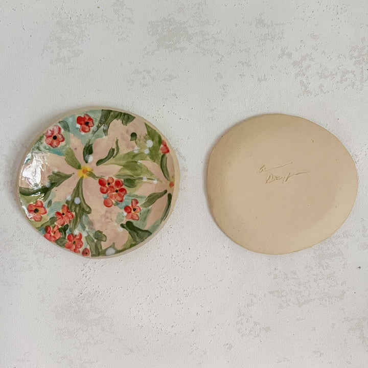 Andrea Durfee | Petite Floral Dishes | A handmade floral ceramic dish with pink, red, green, and yellow. Dish is also flipped over to reveal the natural clay underside and signature.