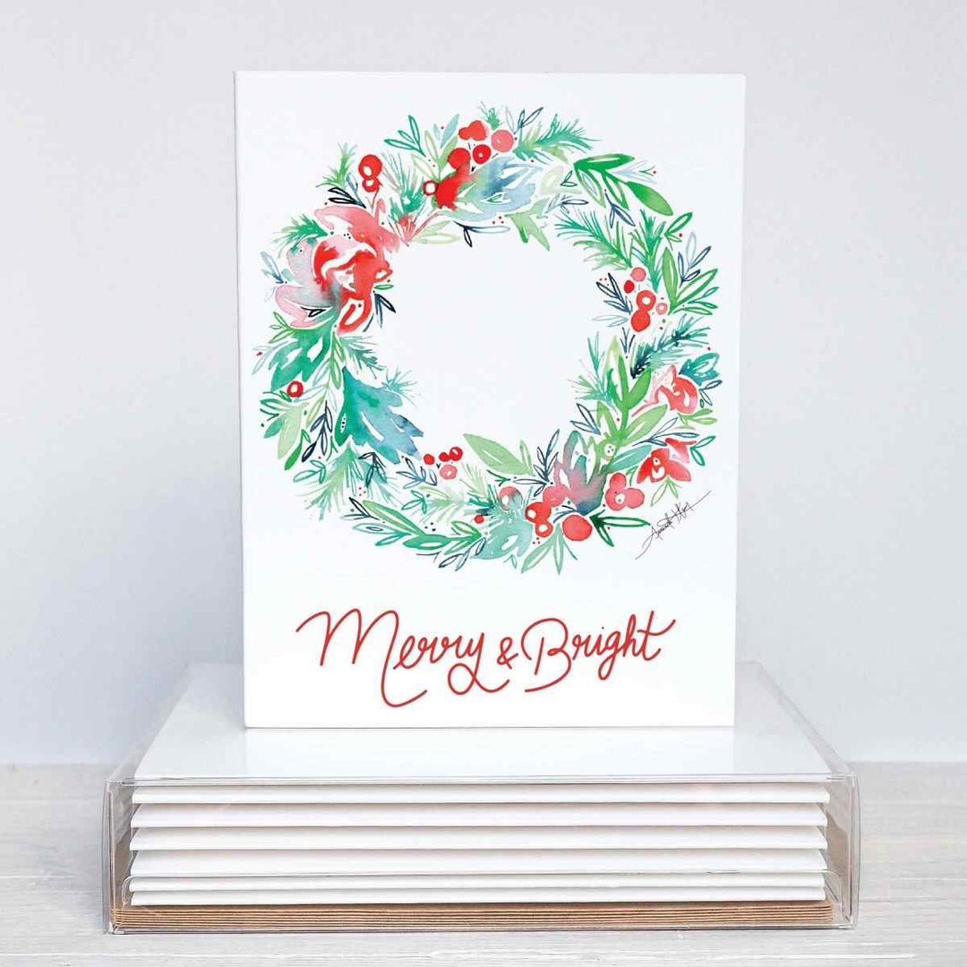 Amanda Klein Co. | Merry & Bright Notecard Stationery Set | A white card with a watercolor wreath on the front and text that reads "Merry & Bright".