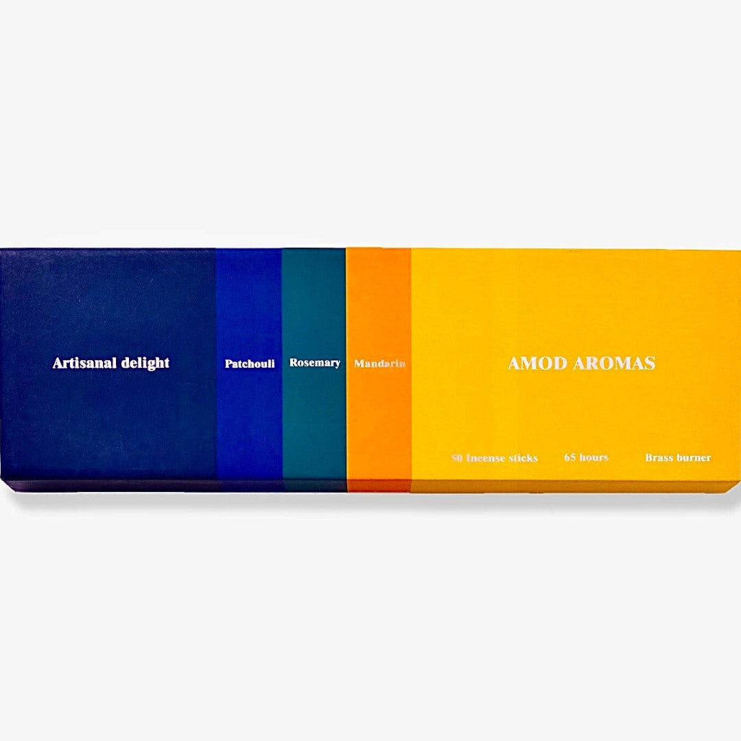 Amod | Artisanal Delight Incense | A colorful box with a blue to yellow gradiant. Patchouli, rosemary, mandarin. Comes with a brass burner.