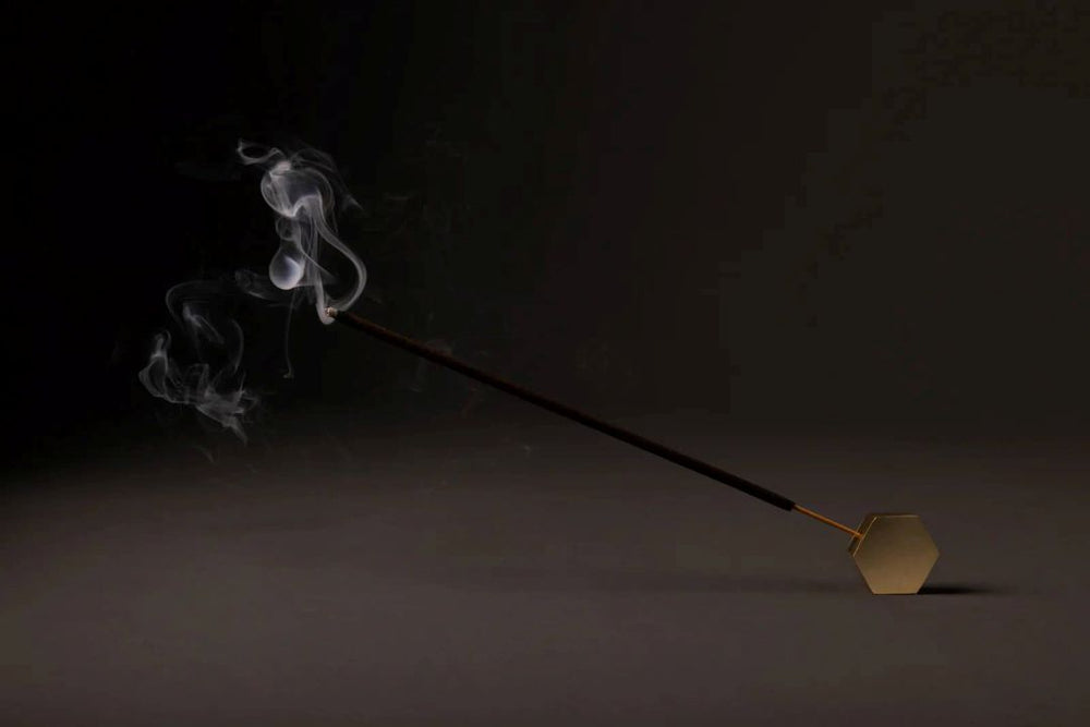 Amod | Incense | Celestial Scent incense. A gold horizontal burner with a burning incense stick.