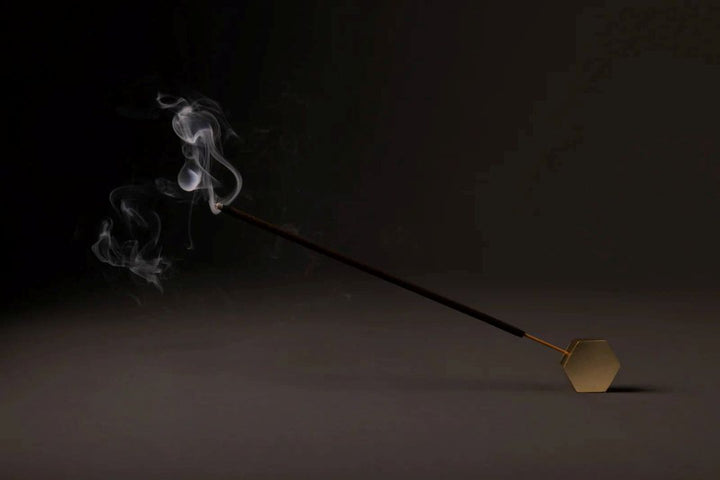 Amod | Incense | Celestial Scent incense. A gold horizontal burner with a burning incense stick.