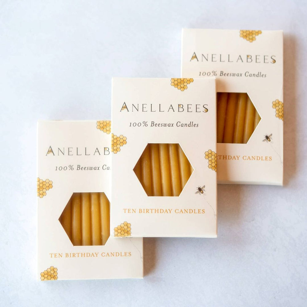 Anellabees | 100% beeswax candles | ten candlers per box | Three boxes of Anellabees birthday candles on a light gray background