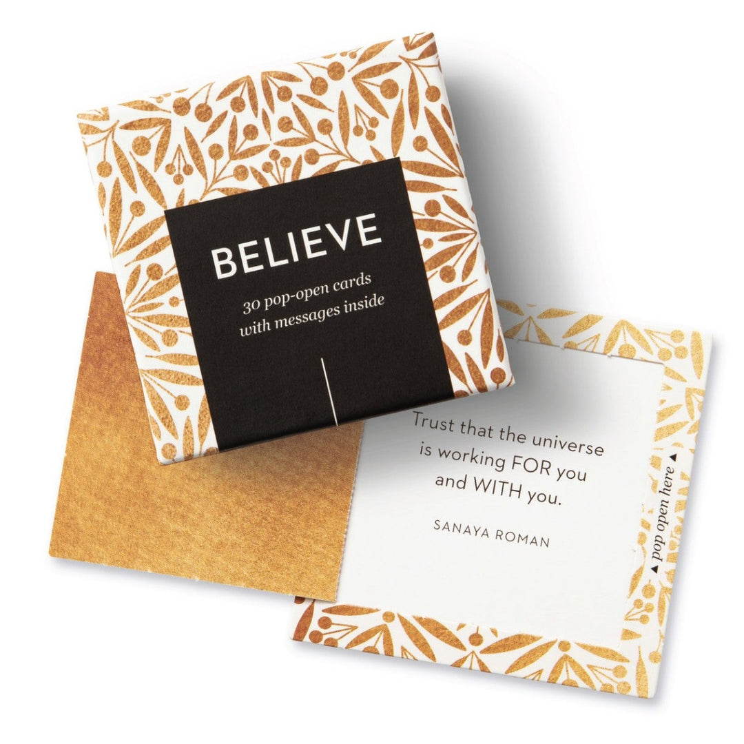 Believe | A box of pop-open cards with messages inside. 30 cards included. Open card reads "Trust that the universe is working FOR you and WITH you. Sanaya Roman". A gold and white box.