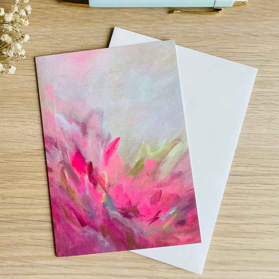 Beth Garner | Greeting card with abstract pink design on a wooden surface with flowers and a pen.