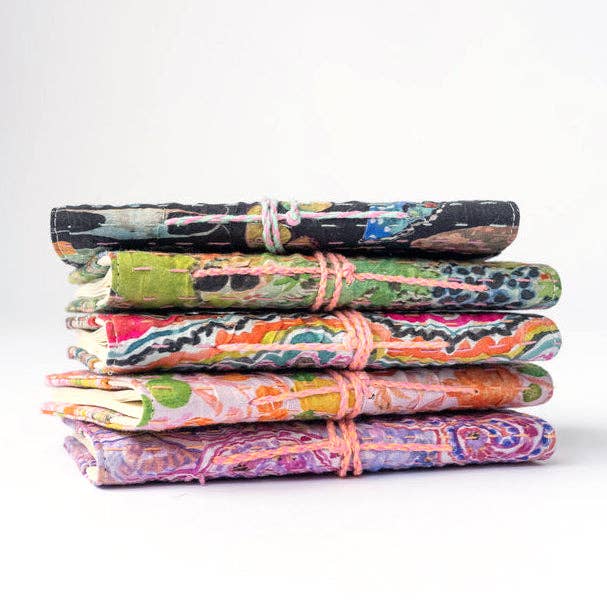 Stack of colorful folded fabrics journals on a white background