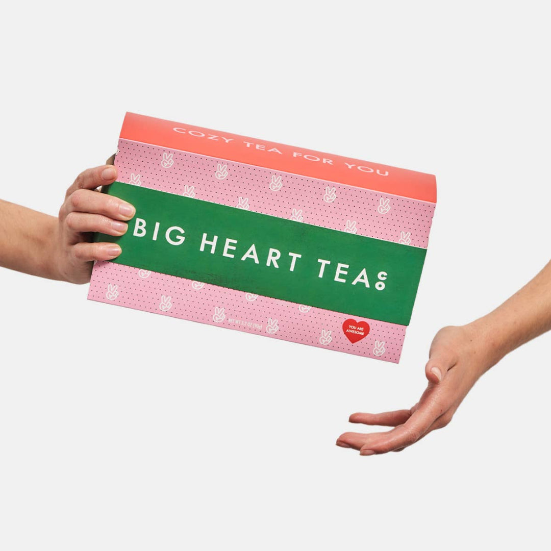 Person holding a Big Heart Teas box against a white background